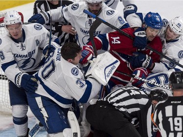 Montreal Canadiens' Tomas Plekanec is pulled away from Tampa Bay Lightning goalie Ben Bishop during skirmish in third-period hockey action Monday, March 30, 2015 in Montreal.