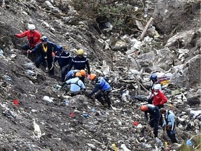 French gendarmes and investigators work last Thursday in the scattered debris on the crash site of the Germanwings Airbus A320 that crashed in the French Alps above the southeastern town of Seyne. The young co-pilot of the doomed Germanwings flight that crashed on March 24, appears to have "deliberately" crashed the plane into the French Alps after locking his captain out of the cockpit, French officials said.
