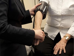 A doctor prepares to check the blood pressure of an elderly stroke patient  at the University of Calgary Foothills Campus in 2012.