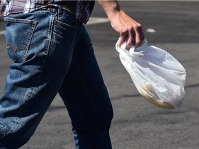 A man carries a plastic bag while leaving a supermarket in Los Angeles in 2014.