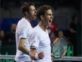 Canada's Vasek Pospisil, of Vancouver and Daniel Nestor, back, of Toronto celebrate after defeating Japan's Go Soeda and Yasutaka Uchiyama in five sets during a Davis Cup tennis world group first round doubles match in Vancouver on Saturday, March 7, 2015.