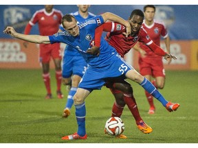 Montreal Impact's Wandrille Lefevre, left, and San Jose Earthquakes' Atiba Harris battle for the ball during first half MLS soccer action in Montreal, Saturday, September 20, 2014.
