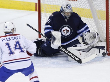 Winnipeg Jets goaltender Ondrej Pavelec (31) gets his toe on the shot from Montreal Canadiens' Tomas Plekanec (14) during first period NHL action in Winnipeg on Thursday, March 26, 2015.
