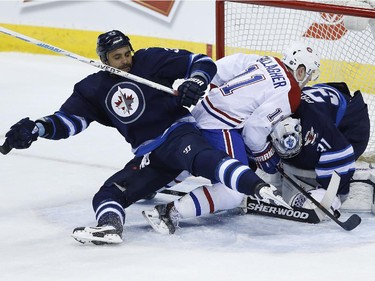 Winnipeg Jets' Dustin Byfuglien (33) and Montreal Canadiens' Brendan Gallagher (11) collide with Jets goaltender Ondrej Pavelec (31) after he makes the save during first period NHL action in Winnipeg on Thursday, March 26, 2015.