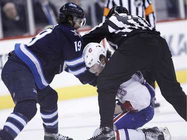 Winnipeg Jets' Jim Slater (19) lays into Montreal Canadiens' Nathan Beaulieu (28) as a lineman attempts to split them up during second period NHL action in Winnipeg on Thursday, March 26, 2015.