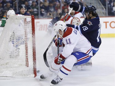 Winnipeg Jets' Jim Slater (19) scores on Montreal Canadiens goaltender Dustin Tokarski (35) as Brendan Gallagher (11) defends during second period NHL action in Winnipeg on Thursday, March 26, 2015.