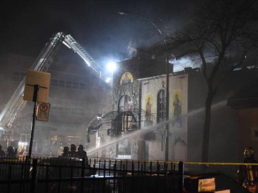Firefighters work to extinguish the blaze at Greek Orthodox church Koimisis Tis Theotokou  at the corner of St-Roch St. and de l'Epée Ave. in Montreal on April 13, 2015.