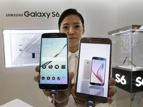 A model poses with a Samsung Electronics Co.'s Galaxy S6, right, and Galaxy S6 Edge, left, smartphones during its launch event at company's headquarter in Seoul, South Korea, Thursday, April 9, 2015. When Samsung dubbed development of its latest smartphones “Project Zero,” it was sounding a note of desperation as sales tumbled and it lost pole position in the crucial Chinese market to rivals Xiaomi and Apple .
