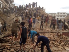 Volunteers help with rescue work at the site of a building that collapsed after an earthquake in Kathmandu, Nepal, Saturday, April 25, 2015.