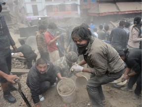 TOPSHOTS People clear rubble in Kathmandu's Durbar Square, a UNESCO World Heritage Site that was severely damaged by an earthquake on April 25, 2015. A massive 7.8 magnitude earthquake killed hundreds of people April 25 as it ripped through large parts of Nepal, toppling office blocks and towers in Kathmandu and triggering a deadly avalanche that hit Everest base camp. AFP PHOTO / PRAKASH MATHEMAPRAKASH MATHEMA/AFP/Getty Images