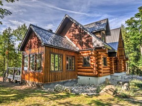 The picturesque log home sits in perfect harmony with its surroundings and features soaring ceilings and open peaks that fill the serene space with light.