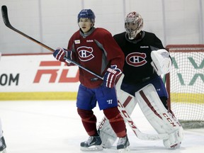 Canadiens goalie Carey Price peers around teammate Brendan Gallagher during practice in Brossard on April 13, 2015.