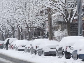 A Montrealer clears snow from her car during a snowfall Sunday, March 15, 2015 in Montreal.