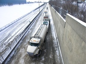 A truck that overturned on the LaSalle side of the Mercier bridge exit in the so-called "whisky trench" is attached to a tow truck, Tuesday, January 16, 2007.