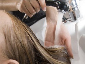 A woman washing hair in a beauty salon.