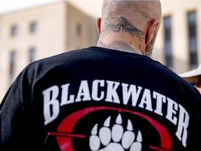 A former member of Blackwater joins family members, friends, and supporters of four former Blackwater security guards outside the federal court in Washington, Monday, April 13, 2015.