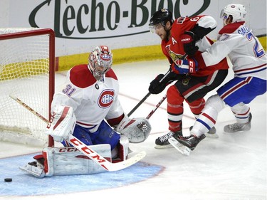 Montreal Canadiens' Carey Price (31) keeps his eye on the puck as Ottawa Senators' Bobby Ryan (6) is boxed out by Canadiens' Alex Galchenyuk (27) during the third period of an NHL Stanley Cup playoff hockey game, Sunday April 26, 2015, in Ottawa.