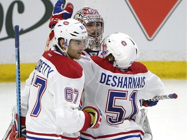 Montreal Canadiens' Carey Price (31) (centre) celebrates after defeating the Ottawa Senators with teammates Max Pacioretty (67) and David Desharnais (51) after the third period of an NHL Stanley Cup playoff hockey game, Sunday April 26, 2015, in Ottawa.