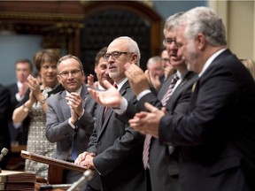 Quebec Finance Minister Carlos Leitao, centre, is applauded by members of the government as he presents the provincial budget Wednesday, June 4, 2014 at the legislature in Quebec City.