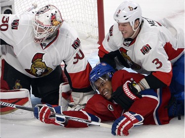 Montreal Canadiens right wing Devante Smith-Pelly (21) is knocked to the ice by Ottawa Senators defenseman Marc Methot (3) in front of Ottawa Senators goalie Andrew Hammond (30) during third period of Game 2 NHL first round playoff hockey action Friday, April 17, 2015 in Montreal.