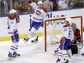 Montreal Canadiens right wing P.A. Parenteau (15) and center David Desharnais (51) celebrate after right wing Devante Smith-Pelly (21) scored a goal during the second period of an NHL hockey game against the Florida Panthers, Sunday, April 5, 2015 in Sunrise, Fla.