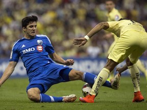 The Impact's Eric Miller, left, fights for the ball with Michael Arroyo of Club America during  CONCACAF Champions League match in Mexico City on April 22, 2015. The match ended in a 1-1 tie.