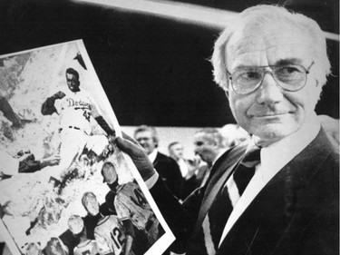 Expos manager Jim Fanning displays a picture of Jackie Robinson while touring the site of the new Carey Diab Baseball Museum of Canada in Montreal on Nov. 26, 1981.
