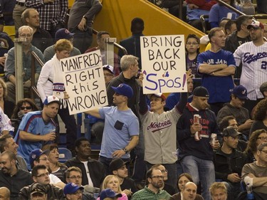 Fans hold up signs as the Toronto Blue Jays face the Cincinnati Reds in Grapefruit League play Friday, April 3, 2015, in Montreal.