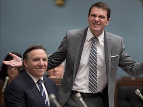 In this file photo, Quebec's second opposition legislature leader Francois Bonnardel grimaces at a comment from Premier Philippe Couillard during question period Wednesday, April 29, 2015 at the legislature in Quebec City. Quebec Second Opposition Leader Francois Legault, left, smiles.