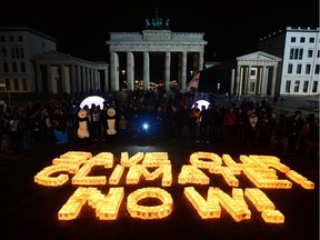 Candles in paper bags are placed to form the lettering "Save our climate, Now" in front of the Brandenburger Gate in Berlin during the the global climate change awareness campaign "Earth Hour" on March 28, 2015.