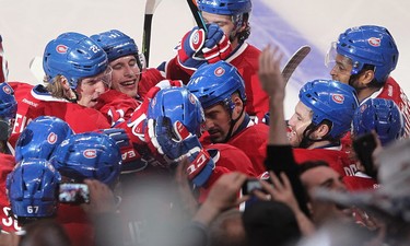 Montreal Canadiens crowd around Alex Galchenyuk, back to camera, following goal  against Ottawa Senators, during overtime action in Montreal on Friday April 17, 2015. The Montreal Canadiens meet the Ottawa Senators in the first round of the NHL playoffs.