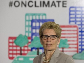 Ontario Premier Kathleen Wynne listens to questions from the media during an announcement which outlined a cap and trade deal with Quebec aimed at curbing green house emissions, in Toronto on Monday, April 13 2015. The plan involves government-imposed limits on emissions from companies, and those that want to burn more fossil fuels can buy carbon credits from those that burn less than they are allowed.