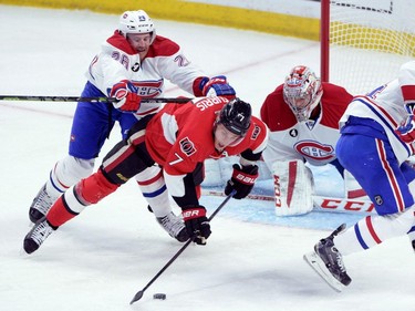 Ottawa Senators forward Kyle Turris, centre, stays on the puck as he gets cross checked to the ice by Montreal Canadiens defenceman Jeff Petry, left, during the first period of game 3 of first round Stanley Cup NHL playoff hockey action in Ottawa on Sunday, April 19, 2015.