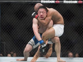 Demetrious Johnson, from the United States, right, takes Kyoji Horiguchi, from Japan, down during their UFC 186 flyweight title fight in Montreal, Saturday, April 25, 2015.