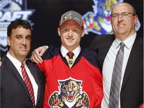 Michael Matheson, centre, a defenseman, stands with Florida Panthers officials after being chosen 23rd overall in the first round of the NHL hockey draft on Friday, June 22, 2012, in Pittsburgh.
