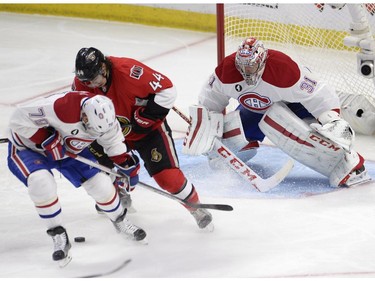 Montreal Canadiens goalie Carey Price watches the puck as Ottawa Senators' Jean-Gabriel Pageau (44) as Canadiens' Andrei Markov (79) battle for control during the first period Stanley Cup NHL playoff hockey action in Ottawa on Wednesday, April 22, 2015.