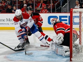 Devante Smith-Pelly #21 of the Montreal Canadiens can't control the puck during the third period in front of Keith Kinkaid #1 of the New Jersey Devils at the Prudential Center on April 3, 2015 in Newark, New Jersey. (EDITORS NOTE: This image was created with multiple in-camera exposures)