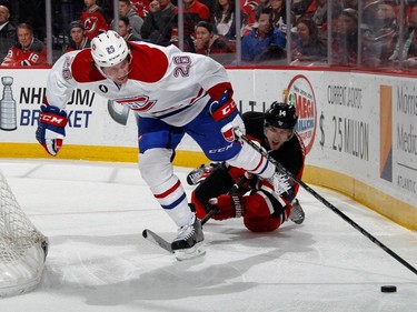 Jeff Petry #26 of the Montreal Canadiens is tripped up by Adam Henrique #14 of the New Jersey Devils during the second period at the Prudential Center on April 3, 2015 in Newark, New Jersey.