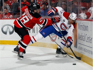 Max Pacioretty #67 of the Montreal Canadiens is pushed into the boards by Damon Severson #28 of the New Jersey Devils during the first period at the Prudential Center on April 3, 2015 in Newark, New Jersey.