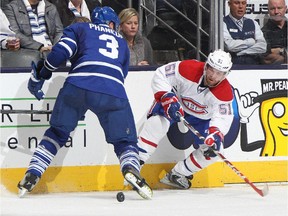 The Habs' David Desharnais tries to chip the puck past Leafs defenceman Dion Phaneuf during the NHL season opener at the Air Canada Centre on October 8, 2014. The Canadiens and Leafs close out the regular season with a tilt on Saturday.