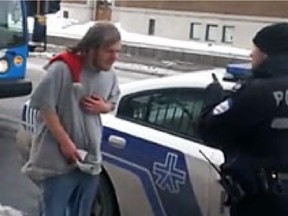 A frame grab from YouTube of a Montreal police officer threatening on Thursday January 2, 2014 to tie a street beggar, clad only in a T-shirt, short jeans and sneakers, to a pole for an hour in the freezing cold near the Jean-Talon metro.