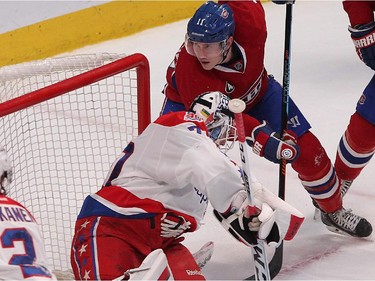 Montreal Canadiens' Brendan Gallagher keeps his eyes on flying puck in front of Washington Capitals goalie Braden Holtby, during first period NHL action in Montreal on Thursday April 2, 2015.