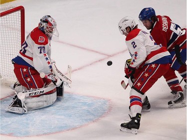 Montreal Canadiens' David Desharnais keeps his eye on the puck has he goes towards Washington Capitals goalie Braden Holtby, with Matt Niskanen closing in, during first period NHL action in Montreal on Thursday April 2, 2015.