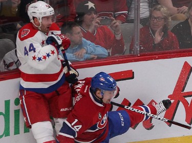 Montreal Canadiens' Tomas Plekanec, right, goes down to the ice following hit on Washington Capitals' Brooks Orpik, during first period NHL action in Montreal on Thursday April 2, 2015.
