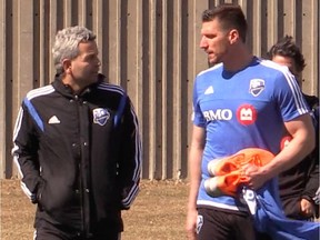 New Impact player Kenny Cooper and coach Frank Klopas speak on their way to the field for practice on April 14, 2015.