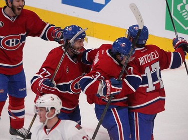 Habs' Tom Gilbert, from left, Brian Flynn and Torrey Mitchell celebrate Flynn's winning goal during the second period at  the Bell Centre on Wednesday, April 15, 2015.