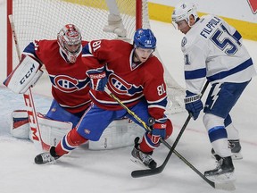 Montreal Canadiens centre Lars Eller, centre, fights for the puck against Tampa Bay Lightning centre Valtteri Filppula, right, as Canadiens goalie Carey Price, left, looks on during the first period of their third NHL Eastern Conference quarter-final playoff game at the Bell Centre in Montreal on Sunday, April 20, 2014.