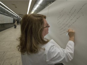 Social worker Angela Teixeira, who has worked at the Royal Victoria Hospital for over 30 years, writes a personal message on banners at the building's entrance.