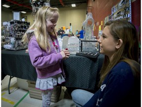 Six-year-old Tess Christen gets a little help in choosing some new jewelry from Olivia Gaston at the first ever craft fair organized by the Forest Hill Home & School Association in St-Lazare, a suburb west of Montreal on Saturday, April 25, 2015.