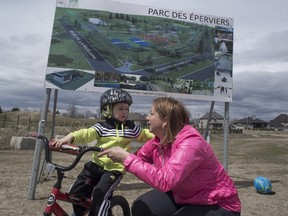 Notre-Dame-de-l'Île-Perrot Mayor Danie Deschenes speaks with her son Nathan, in front of a sign promoting the Parc des Eperviers on Sunday, April 26, 2015.